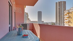 A balcony with a table, a potted plant, and a bowl of strawberries. - Praia DA Rocha Central With Pool (Portimão)
