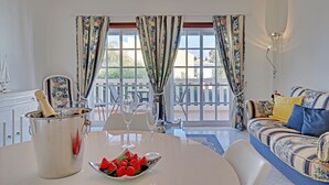 A dining area with a table set for two, a champagne bucket, and a bowl of strawberries. - Portimão Solar DO VAU With Pool (Portimão)