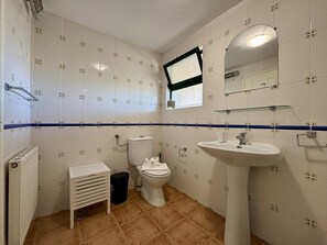 A bathroom with white tiled walls, a white sink, a toilet, and a window. - Algarve Country Villa With Pool (Sao Bras de Alportel)