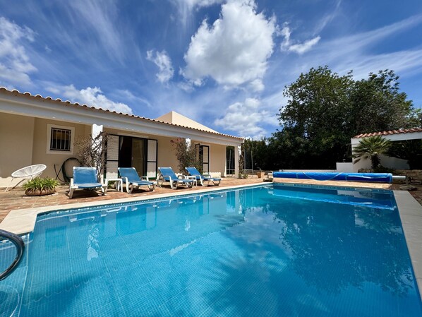 A swimming pool with lounge chairs, a covered area, and a building with windows and a door. - Algarve Country Villa With Pool (Sao Bras de Alportel)