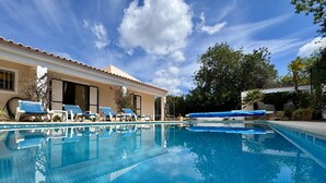 A swimming pool with lounge chairs, a building with a tiled roof, and trees in the background. - Algarve Country Villa With Pool (Sao Bras de Alportel)