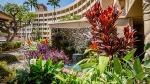 A hotel courtyard with a pool, lush greenery, and a stone waterfall. - Pure Luxury Kihei Rare 3BR Oceanfront Condo Freshly Redesigned Ocean Views (Kihei)