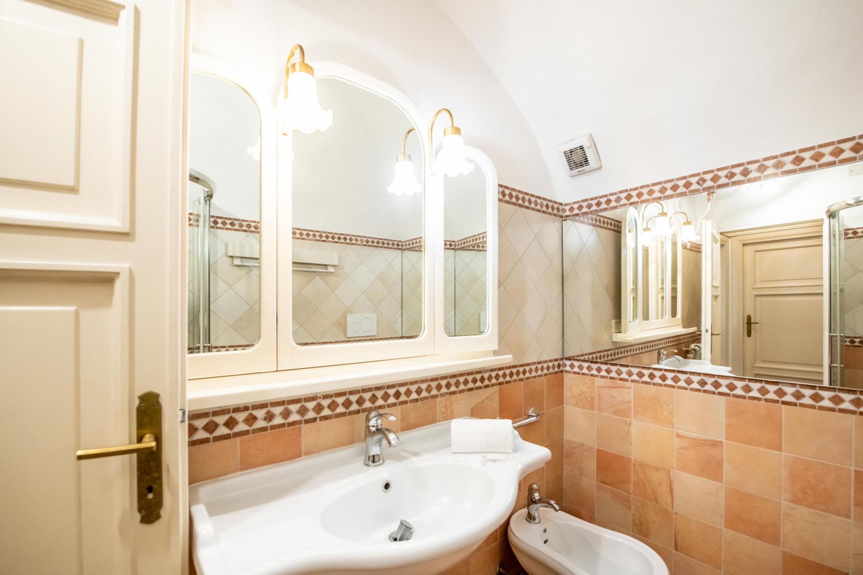 A bathroom with a white sink, a mirror, and a shower.
