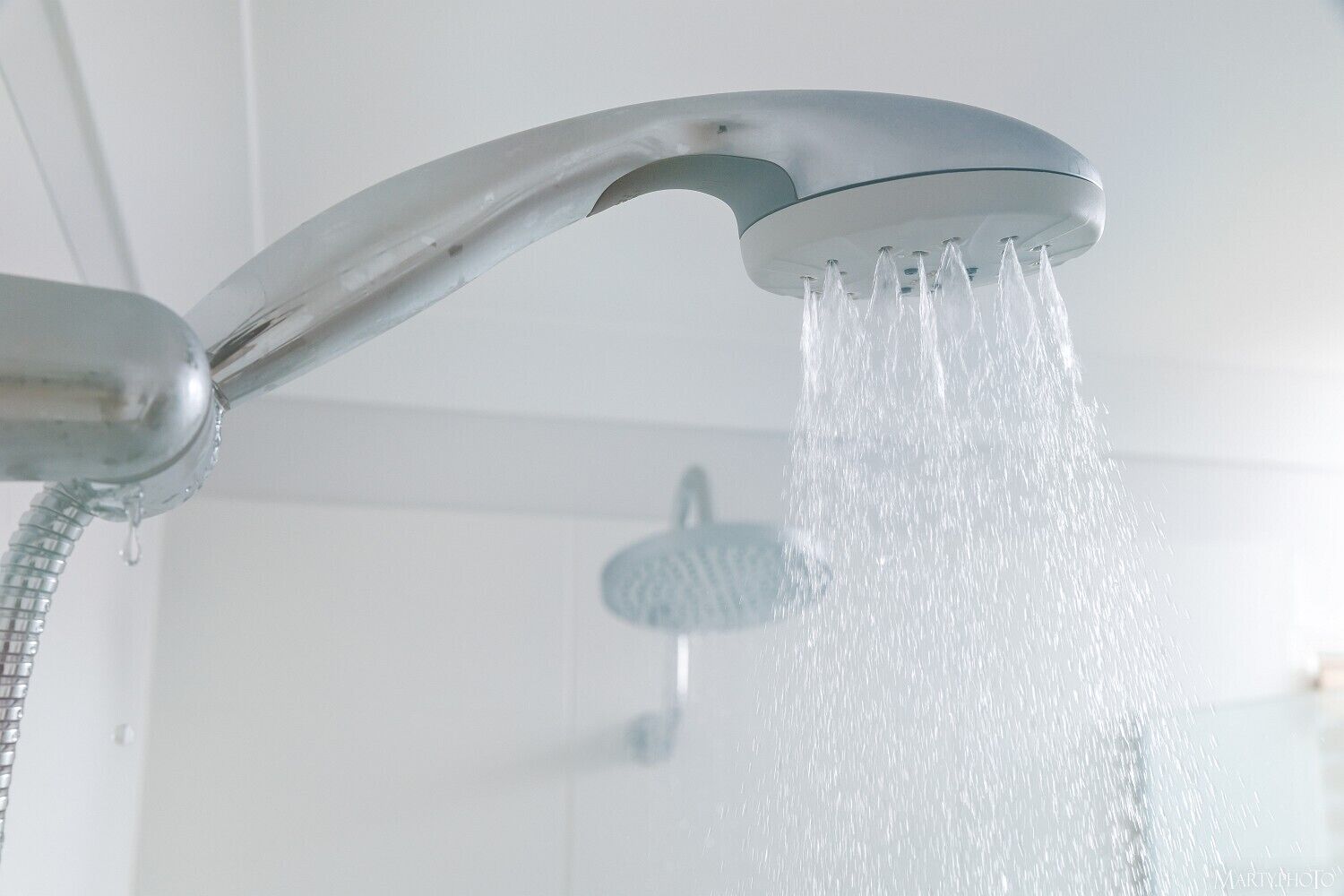 Un cabezal de ducha moderno con agua fluyendo.