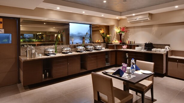Una cocina moderna con una isla central, electrodomésticos integrados y un comedor con mesa y sillas.