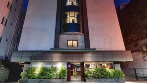 Un edificio moderno con una torre central y una fachada plana.