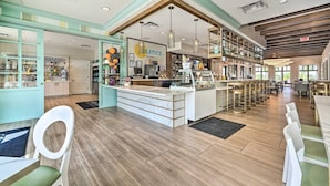 A modern bar area with a central counter, seating arrangements, and a view of the outdoor space.