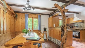 A wooden dining area with a bench, a table, and a rustic tree trunk centerpiece. - Alpine Chalet Metka at Lake Bohinj (Bohinj)