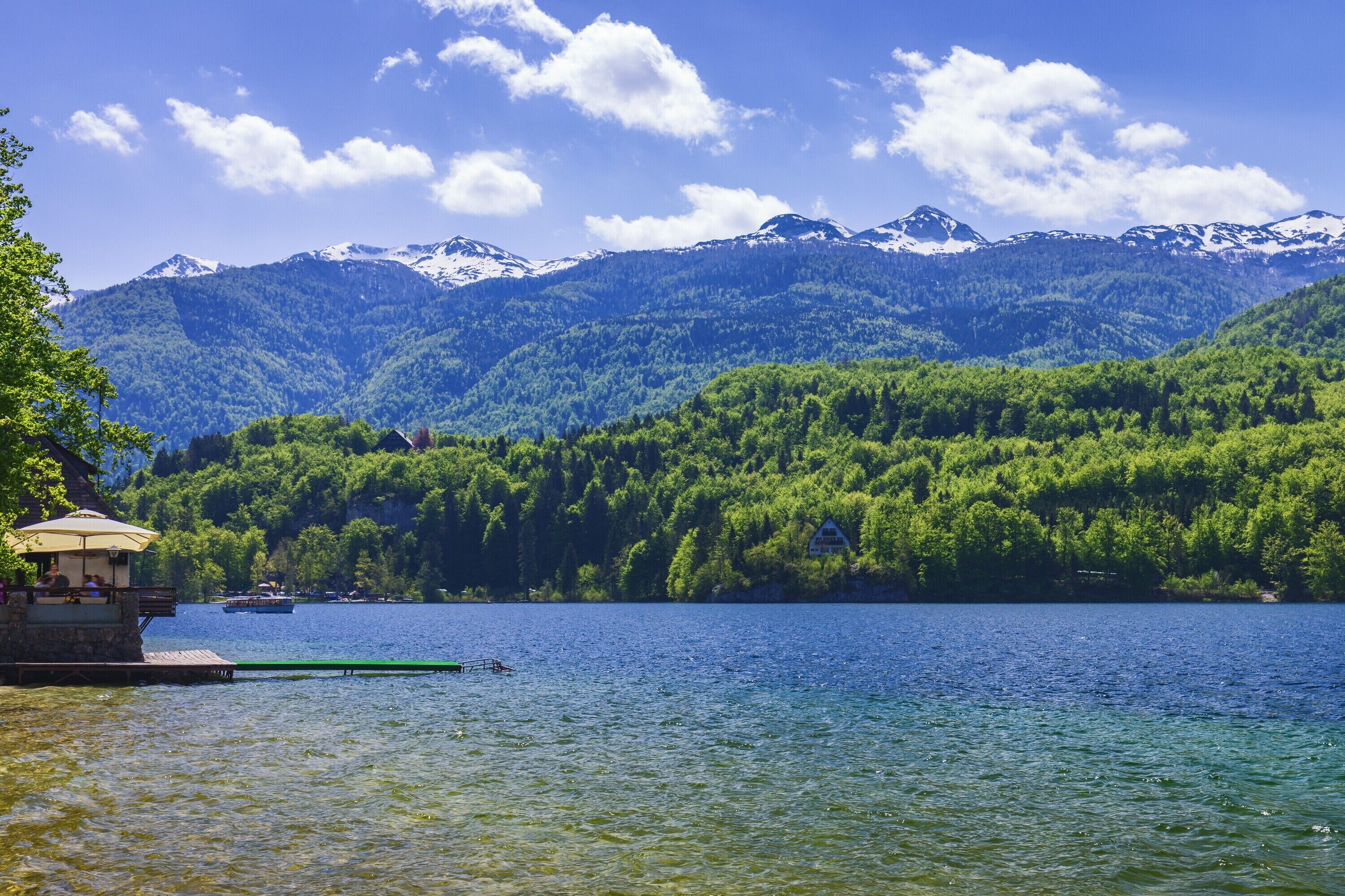 Vista sul lago con un pontile, un piccolo padiglione e una barca.