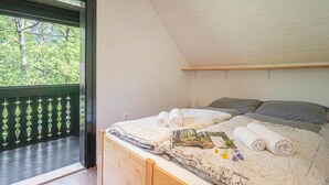 A bedroom with a bed, pillows, and towels. - Alpine Chalet Metka at Lake Bohinj (Bohinj)