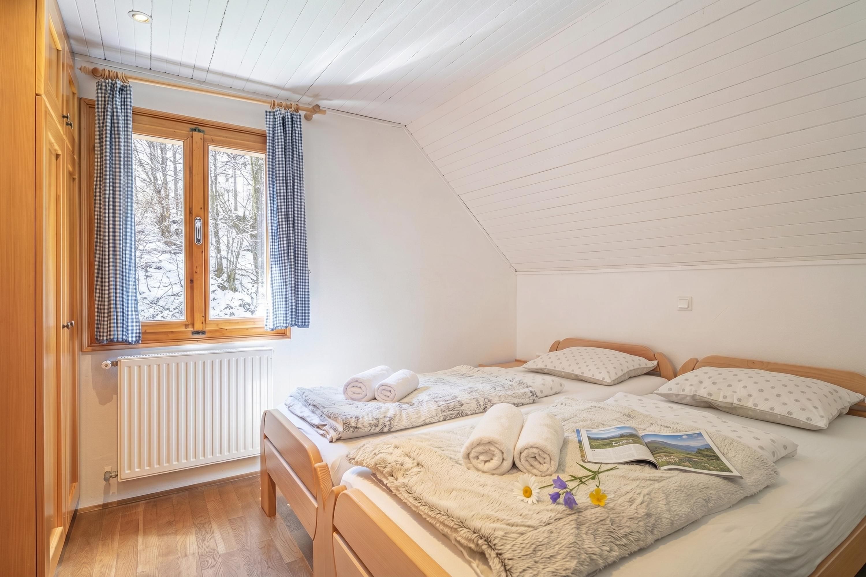 A bedroom with a wooden bed, a radiator, a window with curtains, and a view of trees.