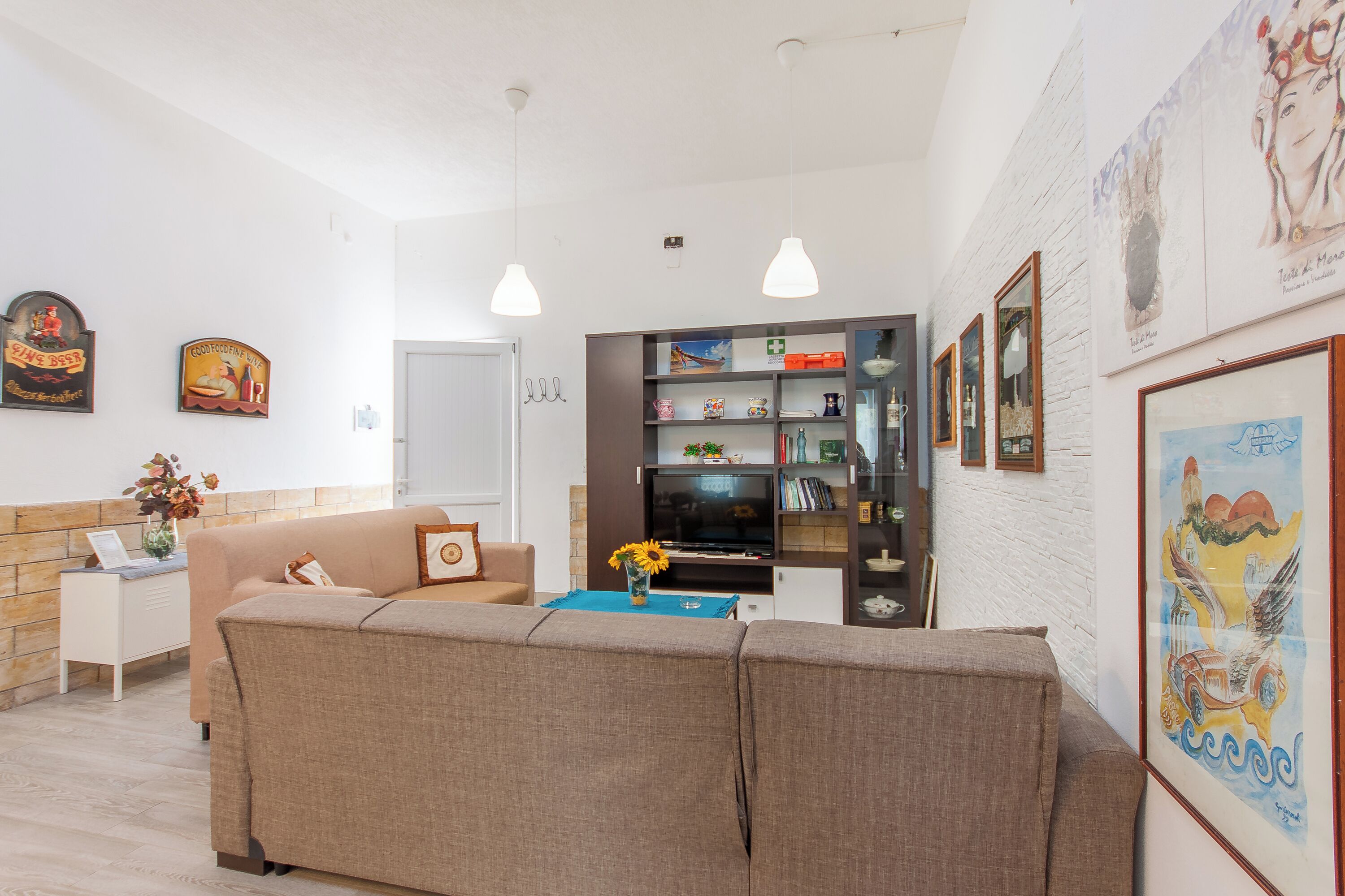 Een woonkamer met een bank, een televisie en een boekenkast.