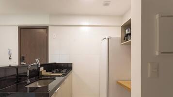 A modern kitchen with a black countertop, stainless steel faucet, and a built-in oven.