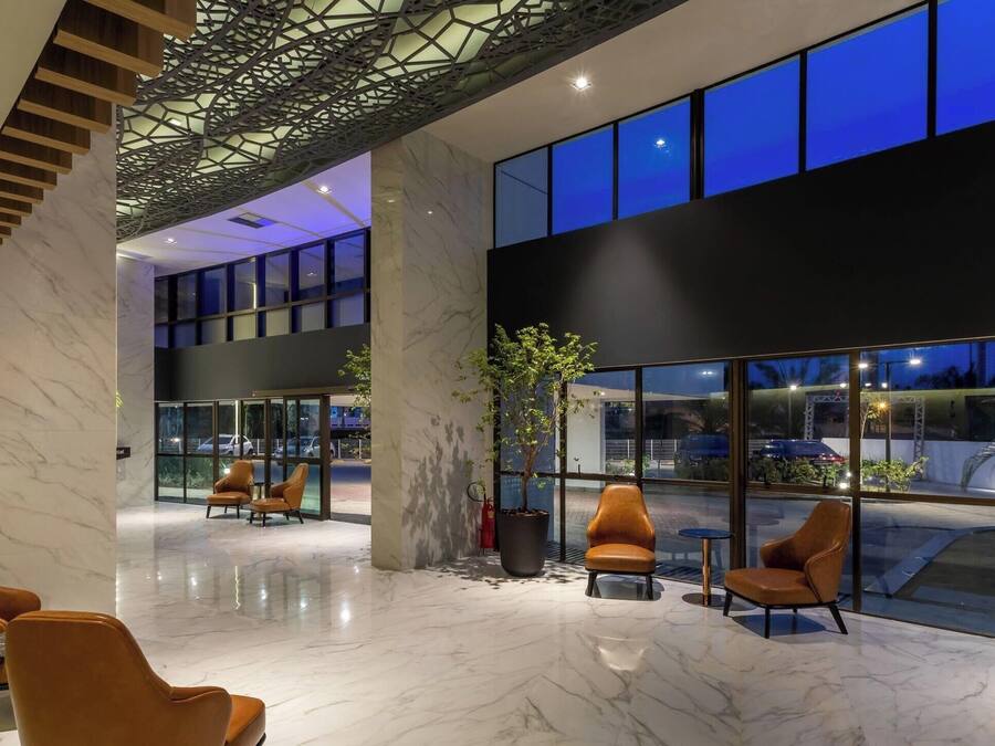 A modern lobby with marble flooring, leather seating, and large windows.