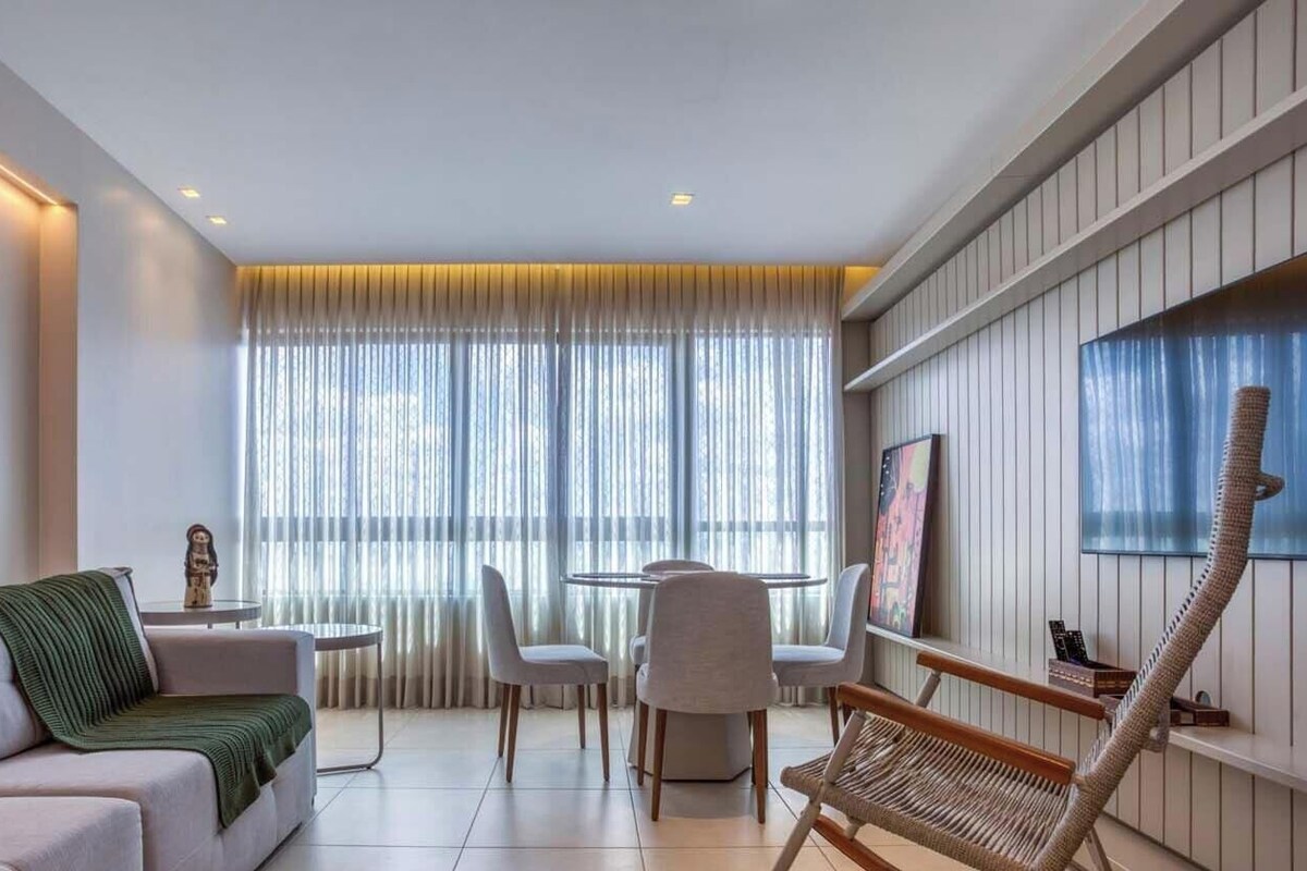Un salon moderne avec un canapé, une table basse et un téléviseur fixé au mur.