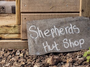 A sign on the ground that reads 'Shepherds Hut Shop.'