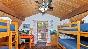 Ein gemütliches Zimmer mit Etagenbetten, einem Schreibtisch, einem Computer und einem Deckenventilator.