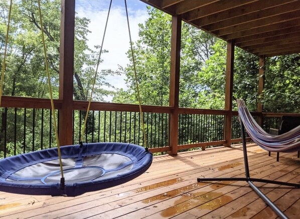 Relax in a hammock or unwind in the hot tub on this deck overlooking a lush forest.