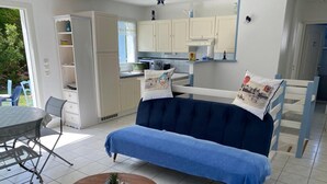 Uma sala de estar com sofá, mesa de centro e área de jantar com cadeiras.