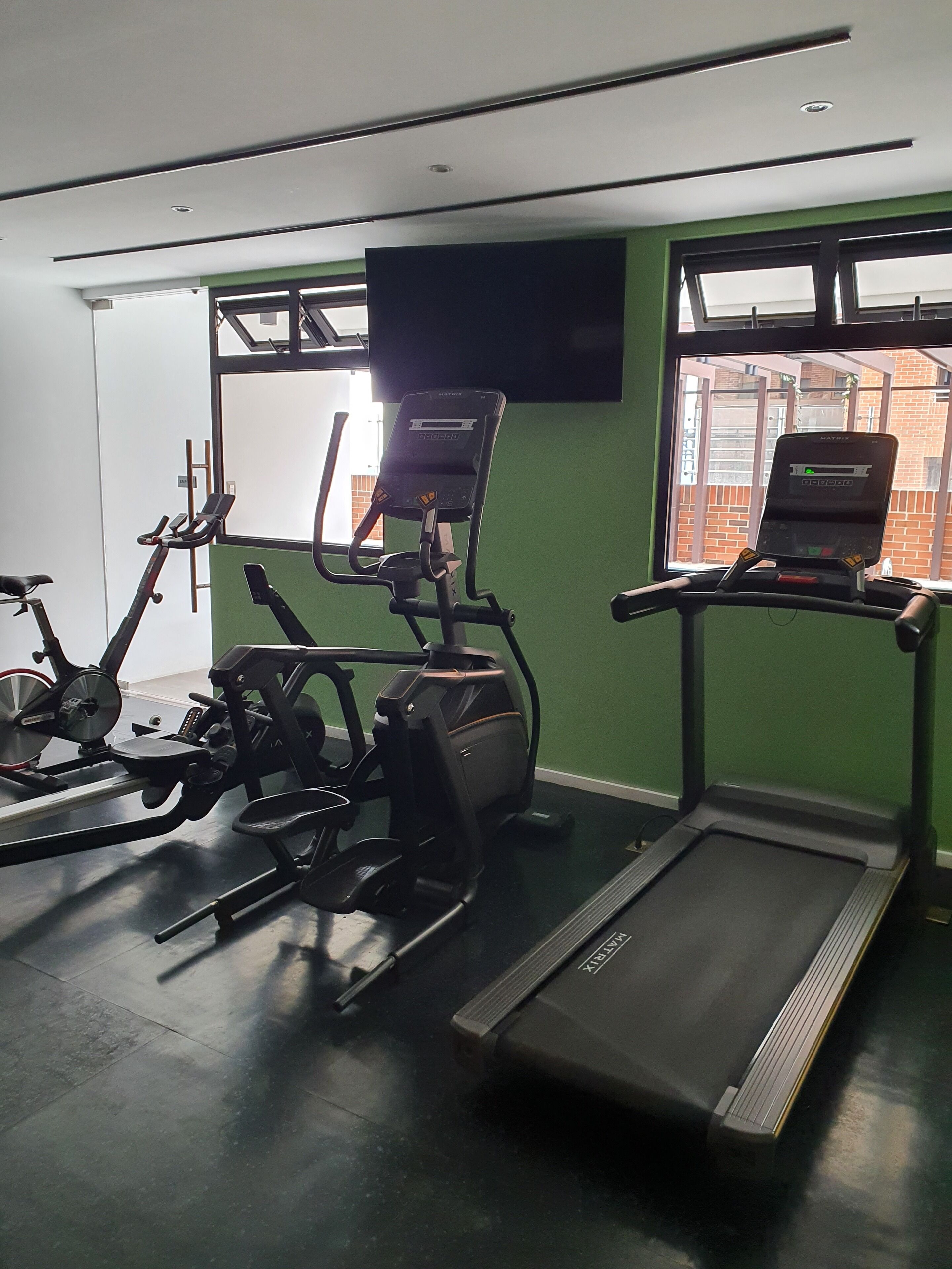 A gym with stationary bikes, an elliptical, and a treadmill.