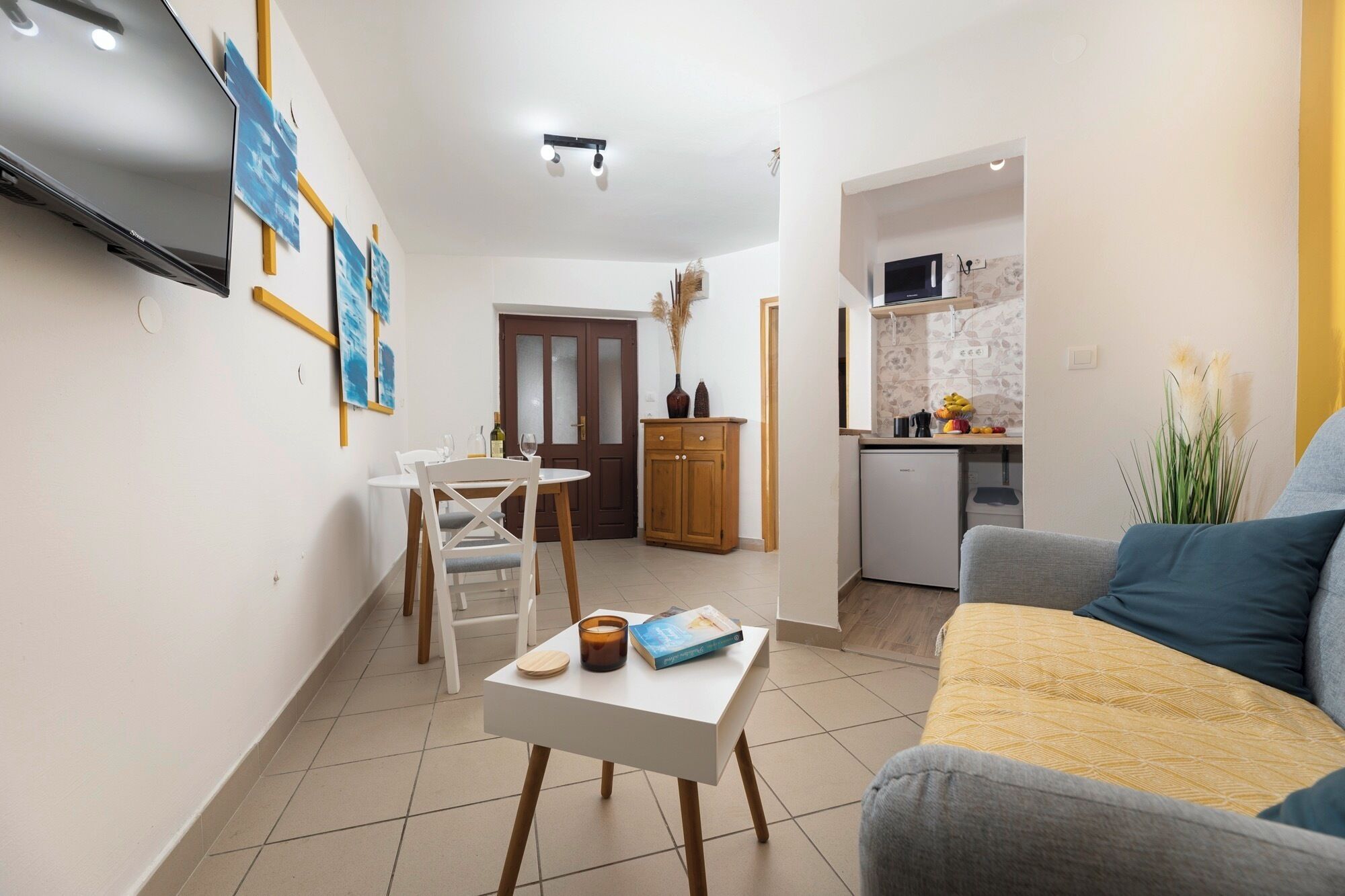 Un espacio habitable compacto con comedor, kitchenette y sofá.