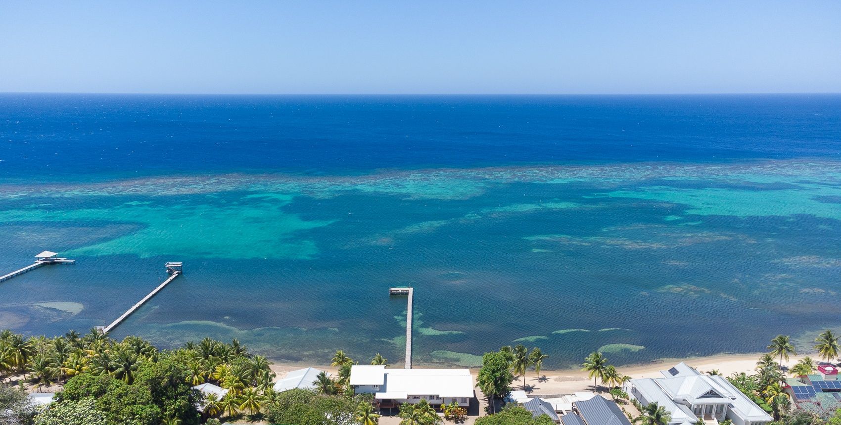 Vue aérienne d’une zone côtière où l’on distingue deux propriétés : Casa Coral et Casa Palmera.