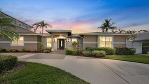 A residential house with a front entrance, a driveway, and well-maintained landscaping.