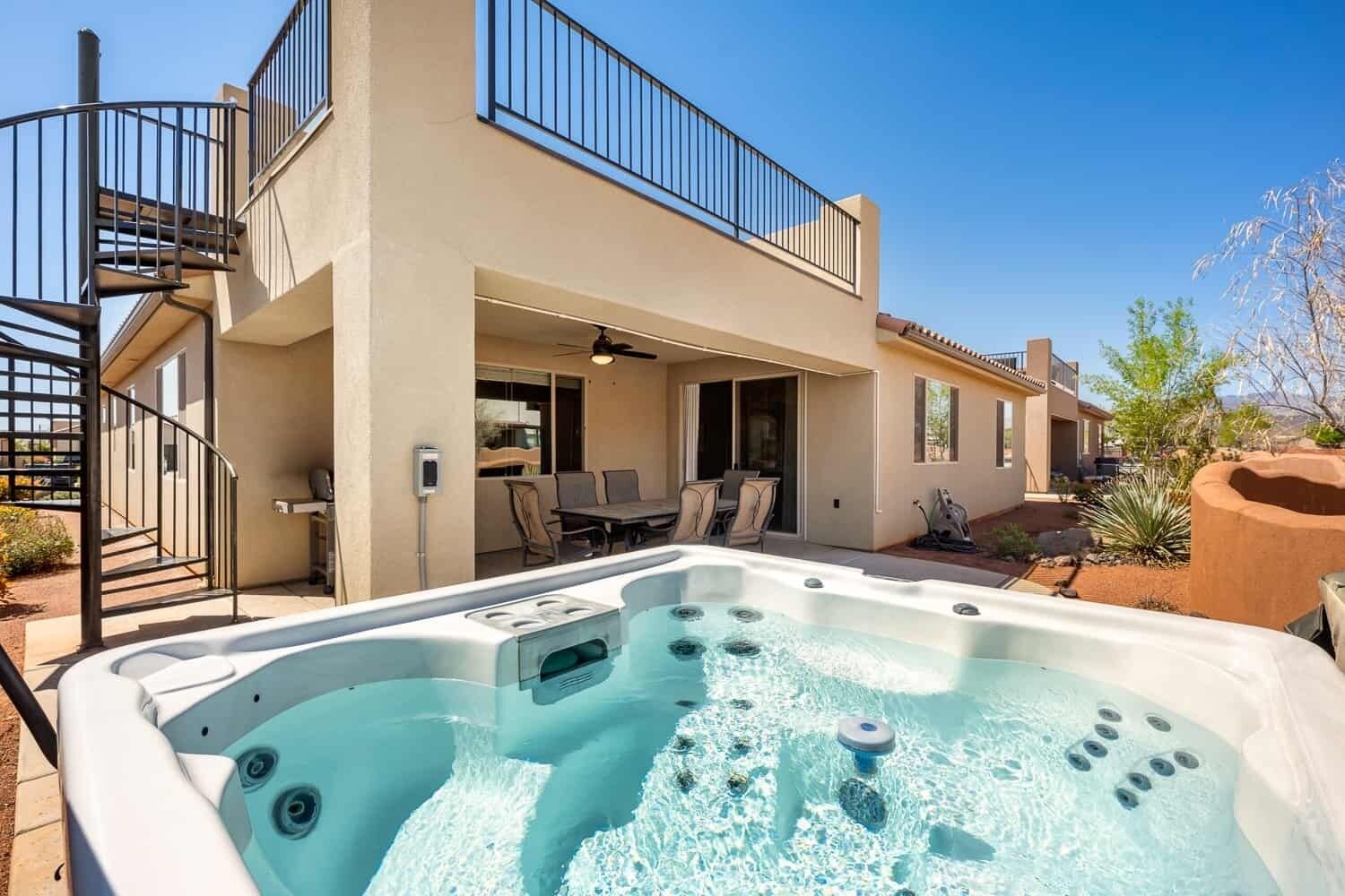 A two-story house with a hot tub in the backyard.