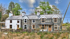 A stone house with multiple windows and a chimney.