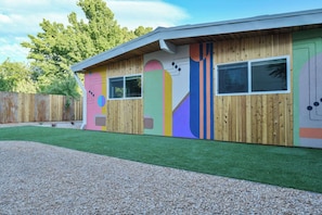 A building with a wooden exterior, two windows, and a colorful mural. - Moab Inn Towner #3 - Heart of Downtown (Moab)