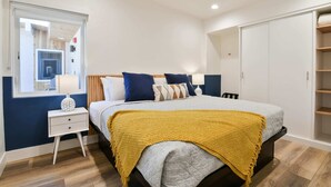 A bedroom with a bed, bedside tables, a wardrobe, and a window. - Moab Inn Towner #4 - Heart of Downtown (Moab)
