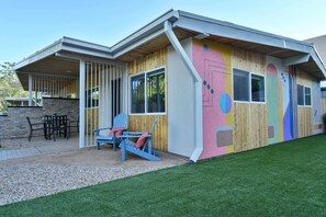 A modern house with a wooden exterior, a covered patio with outdoor furniture, and a well-maintained lawn. - Moab Inn Towner #4 - Heart of Downtown (Moab)