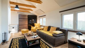 Uma sala de estar moderna com sofá, mesa de centro e uma janela grande.