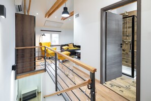 A modern interior with a staircase, a living area with yellow chairs, and a shower area. - Cozy House In Nature With Hot Tub (Jalžabet)
