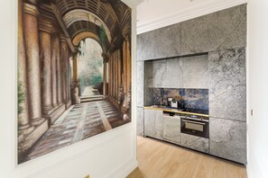 A modern kitchen with marble countertops and a built-in oven.