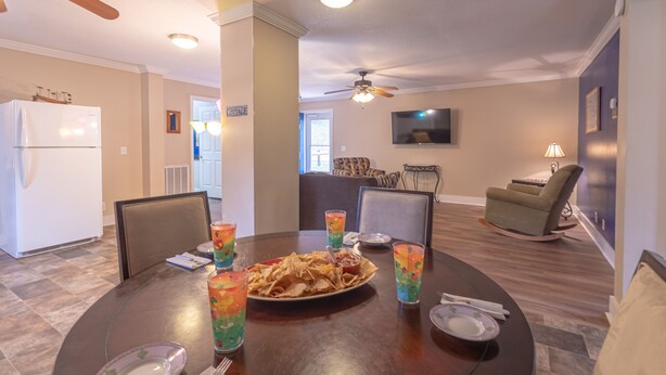 Comedor con una mesa dispuesta para cuatro personas, mostrando un plato de nachos y bebidas de colores.