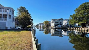 A calm canal with houses on one side and a grassy area on the other. - Waterfront Rancher in South Bethany (Bethany Beach)