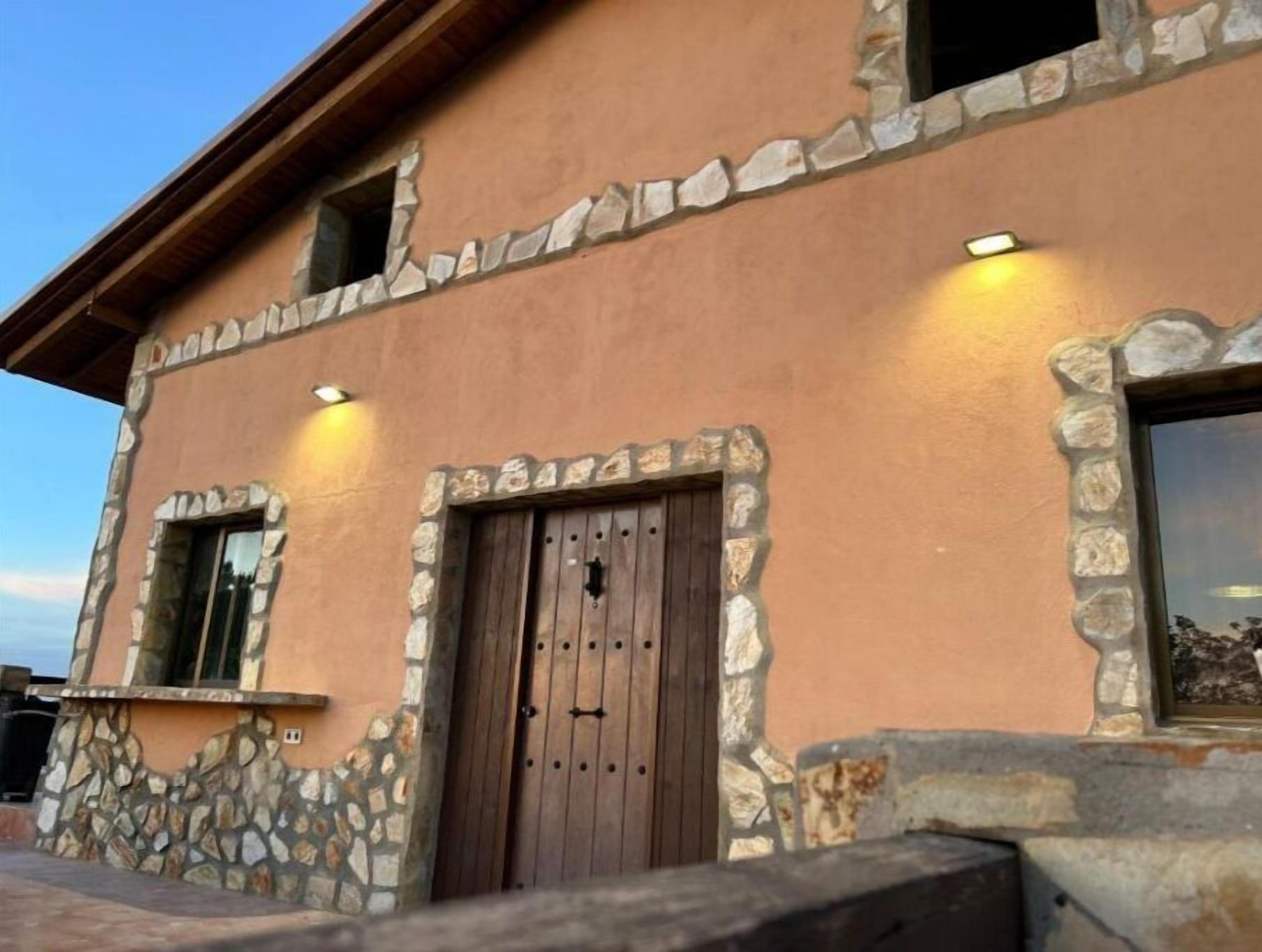Un edificio rústico con detalles de piedra y una puerta de madera.