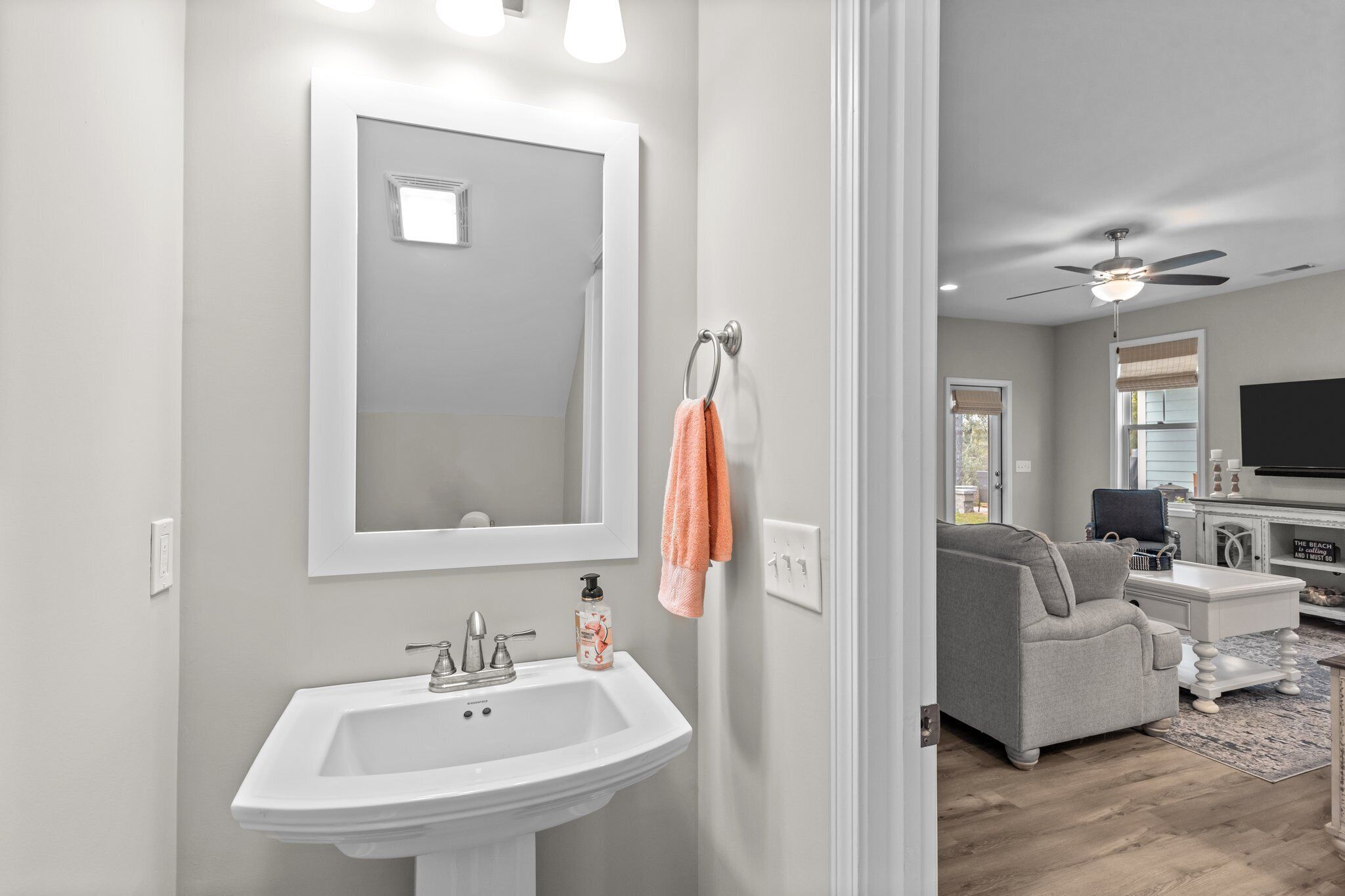 A bathroom with a sink, mirror, and towel rack.