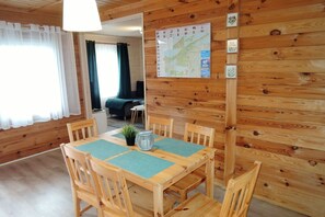 Una habitación con paneles de madera, una mesa de comedor, sillas y un mapa en la pared.