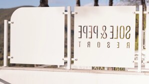 Ein Schild mit dem Text "SOLLE & PEER" auf weißem Hintergrund, an einer Metallkonstruktion befestigt, im Vordergrund eine Metallreling.