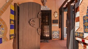 A narrow hallway with a wooden door labeled "CASA DE FUENTES" leading to a room. The walls are decorated with colorful tiles. - The Gaudi House- Pool/Minutes to DNTN and Beach (St. Augustine)