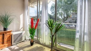 Ein Zimmer mit einer großen Schiebeglasdoor, einem Heizkörper und zwei Blumentöpfen.