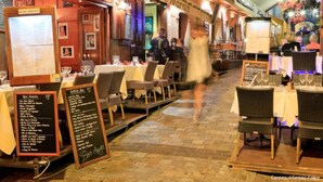 Ein Essbereich im Freien mit gedeckten Tischen, ausgelegten Speisekarten und einem Schild für das Restaurant 'Le Marais'.