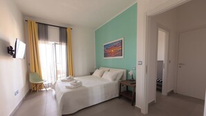 Une chambre à coucher avec un lit, une chaise, une table de chevet et un tableau au mur.