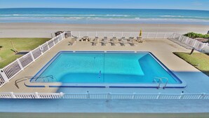 A rectangular pool with a white deck and a white fence. - Direct Oceanfront Townhome with Breathtaking Views of the Beach (New Smyrna Beach)