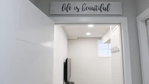 Et badeværelse med et skilt over spejlet, der siger 'life is beautiful'.