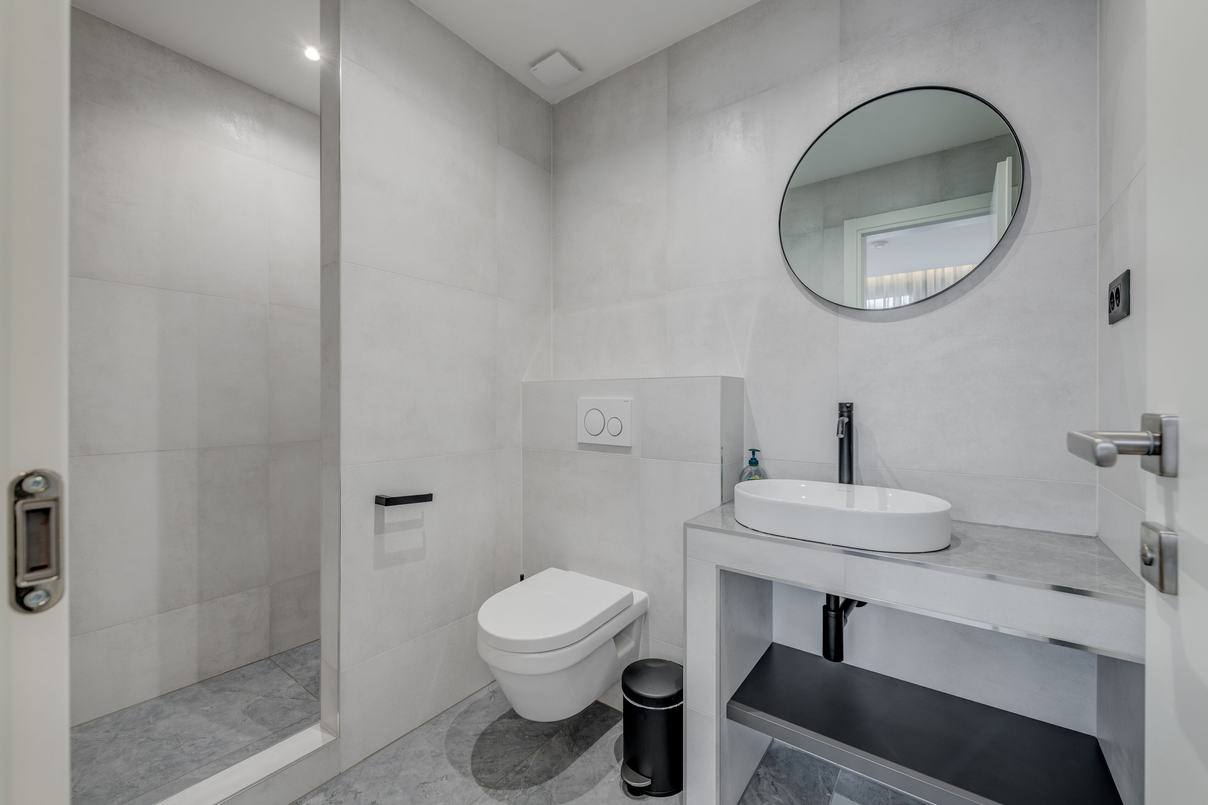 Un baño moderno con inodoro, lavabo y ducha.