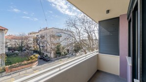 A balcony with a view of a street and buildings.