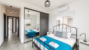A modern bedroom with a large bed, bedside tables, a mirror, and a wardrobe. - Napa Bay View Villa 4 (Ayia Napa)